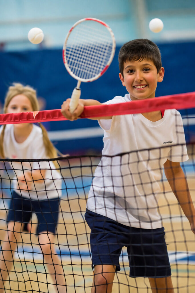 Young badminton player smiling during indoor practice